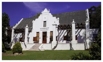 a white house with stairs and a roof at Mooiplaas Wine Estate in Stellenbosch