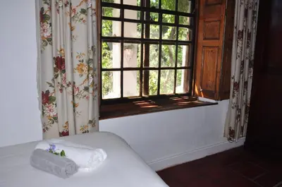 a window with a towel on a bed in a room at Mooiplaas Wine Estate in Stellenbosch