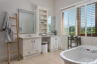 a bathroom with a tub and a sink and a mirror at The Residence @ Vrede & Lust in Franschhoek