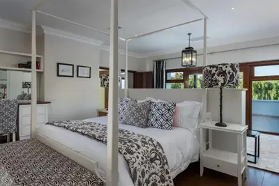 a bedroom with a white bed with a canopy at The Residence @ Vrede & Lust in Franschhoek