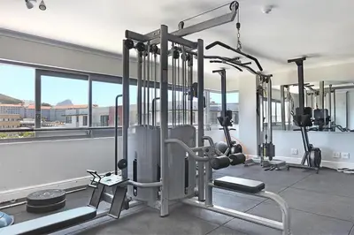 a gym with a bunch of machines in a room at The Paragon 317 in Cape Town