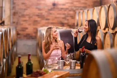 two women sitting at a table drinking wine at Webersburg in Stellenbosch