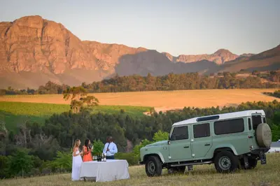 a bride and groom standing next to a table and a truck at Webersburg in Stellenbosch