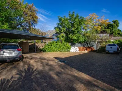 a parking lot with a car parked in a driveway at Eikelower Accommodation in Stellenbosch