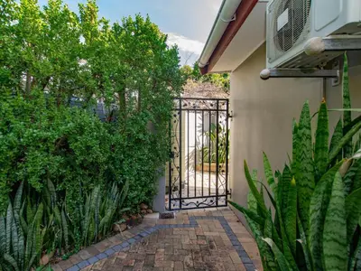 a gate to a house with a brick walkway at Eikelower Accommodation in Stellenbosch