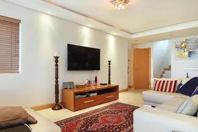 a living room with a couch and a flat screen tv at Dolphin Beach E5 in Bloubergstrand