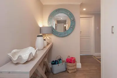 a room with a counter with a mirror and a sink at The Sun, Whales & Waves - Seafront Apartment in Hermanus