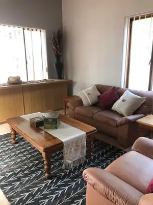 a living room with a couch and a coffee table at The Vineyard View in Joostenberg Vlakte