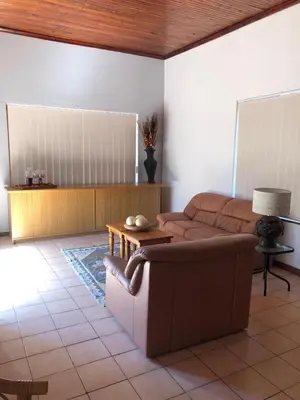 a living room with a couch and a table at The Vineyard View in Joostenberg Vlakte