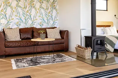 a living room with a couch and a wood stove at Riverbend Farm in Robertson
