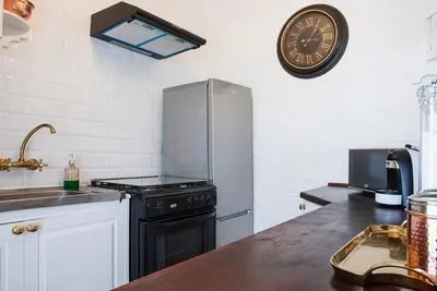 a kitchen with a stove and a clock on the wall at Ridgeworth Cottage in Greyton