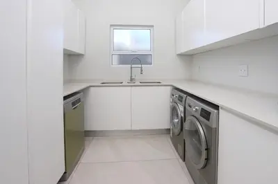 a white kitchen with a sink and a dishwasher at 269 on Main Holiday Home in Hermanus