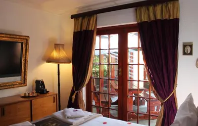 a bedroom with a bed and a sliding glass door at Goblin's Mead in Edgemead