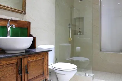 a bathroom with a toilet and a sink and a shower at Goblin's Mead in Edgemead