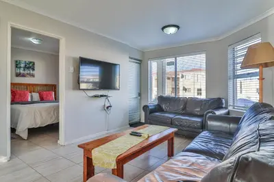 a living room with a couch and a table at 155 hbc in Hermanus