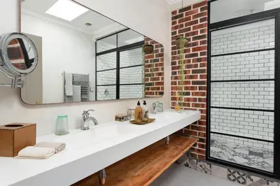 a bathroom with a white sink and a brick wall at De Zeven Guest Lodge in Stellenbosch