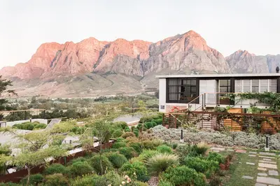 a house with a mountain in the background at De Zeven Guest Lodge in Stellenbosch