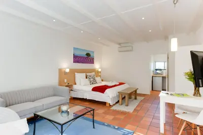 a living room with a bed and a couch at Albourne Guesthouse in Somerset West
