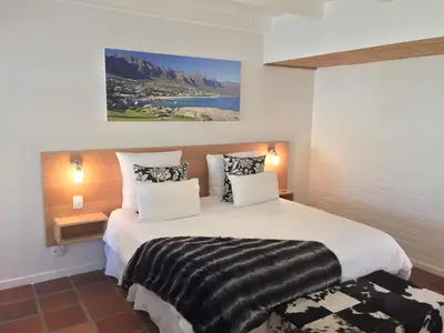 a bedroom with a large white bed with two pillows at Albourne Guesthouse in Somerset West