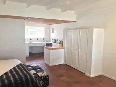 a kitchen with a white refrigerator and a counter at Albourne Guesthouse in Somerset West