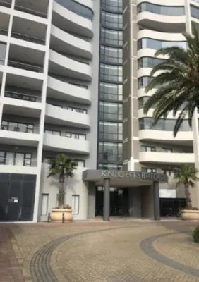 a large building with palm trees in front of it at Home relaxation in the city in Cape Town