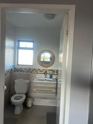 a bathroom with a toilet and a sink and a mirror at Home relaxation in the city in Cape Town