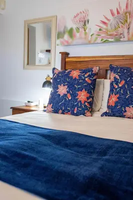 a bedroom with a bed with blue and orange pillows at Stay at Friends Economy Rooms in Malkopvlei