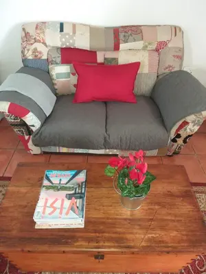 a living room with a couch and a table with flowers at Worcester Gallery Cottage in Worcester