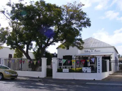 a white building with a fence and a tree at Worcester Gallery Cottage in Worcester
