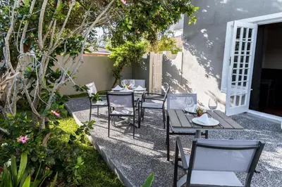 a group of tables and chairs in a garden at Le Petit Chateau Guest House in Durbanville