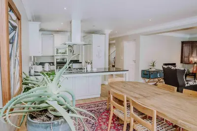a kitchen and dining room with a table and a plant at Franschhoek Village House in Franschhoek