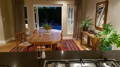 a kitchen with a table and a dining room at Franschhoek Village House in Franschhoek