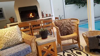 a living room with two chairs and a fireplace at Franschhoek Village House in Franschhoek