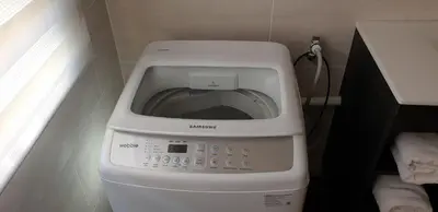a washing machine with its door open in a bathroom at Dawn's Place in Strand