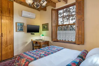 a bedroom with a bed and a tv and a window at Oude Wellington Estate in Wellington