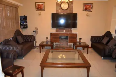 a living room with leather couches and a fireplace at ST@Y-1-BnB in Cape Town