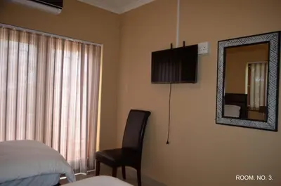 a bedroom with a bed and a mirror and a chair at ST@Y-1-BnB in Cape Town
