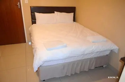 a bed with white sheets and two towels on it at ST@Y-1-BnB in Cape Town