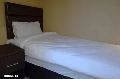 a bed with white sheets and a black headboard at ST@Y-1-BnB in Cape Town
