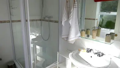 a white bathroom with a sink and a shower at Somerset Sights B&B in Somerset West