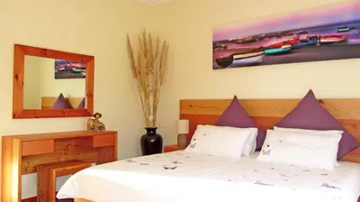 a bedroom with a bed and a mirror at Somerset Sights B&B in Somerset West
