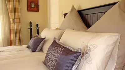 a white bed with pillows on top of it at Somerset Sights B&B in Somerset West