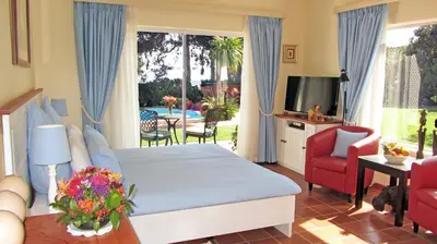 a bedroom with a bed and a living room at Somerset Sights B&B in Somerset West