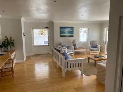 a living room with a couch and chairs and a table at Shore's Edge Luxury Oceanfront Home in Hermanus