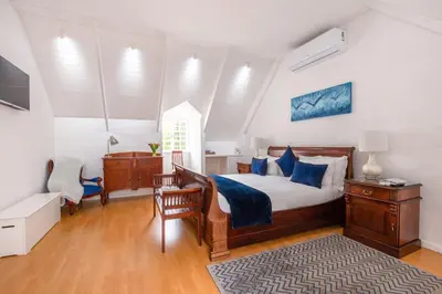 a bedroom with a bed and a desk and a chair at Cosimi Guest House in Durbanville