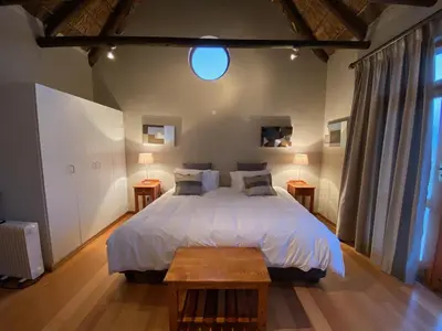 a bedroom with a large white bed with two tables at Lord's Wine Farm in McGregor