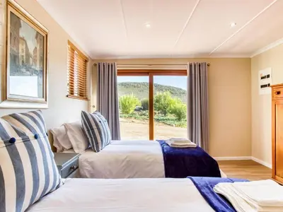 two beds in a room with a window at Lord's Wine Farm in McGregor