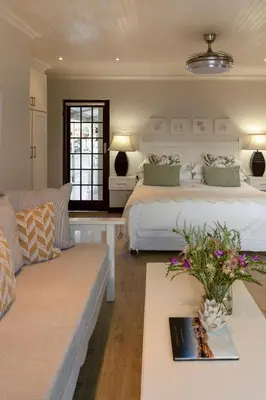 a bedroom with a large bed and a couch at The Potting Shed Guest House in Hermanus