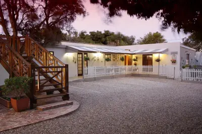 a house with a staircase in front of it at The Potting Shed Guest House in Hermanus