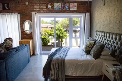 a bedroom with a bed and a large window at the STUDIO apartment in Durbanville in Durbanville